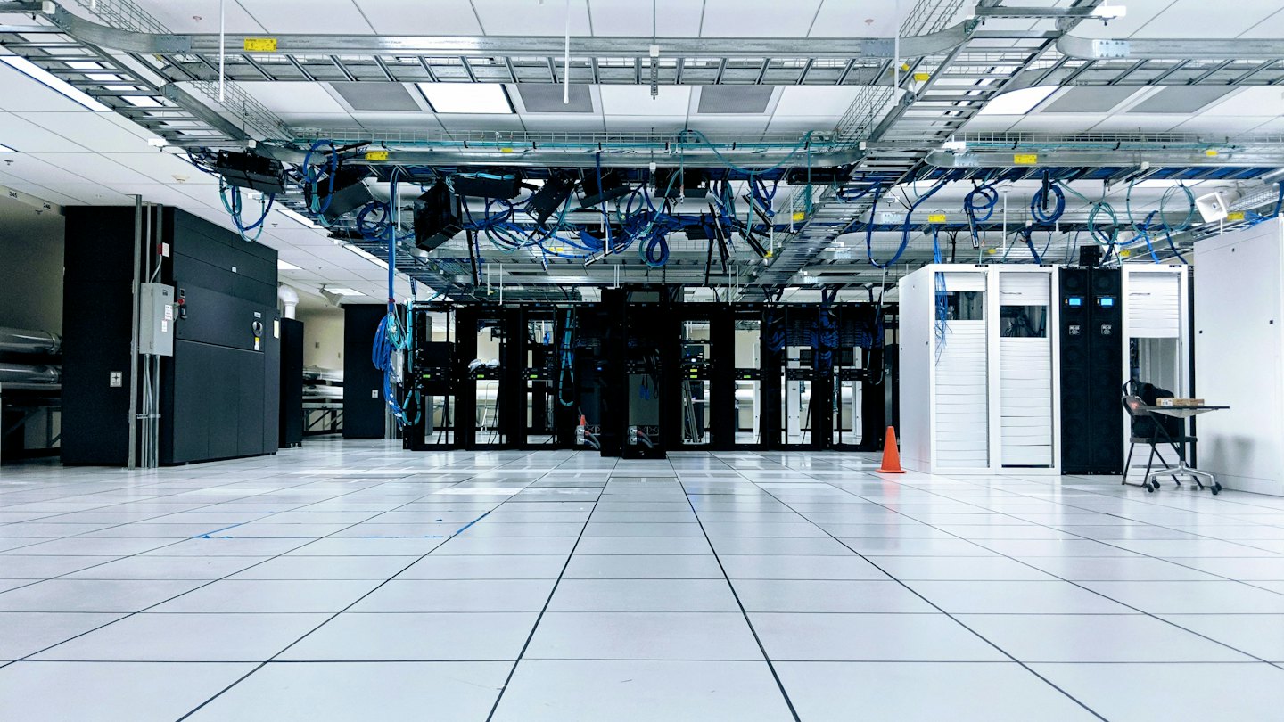 Rows of server racks in a modern, empty data center.
